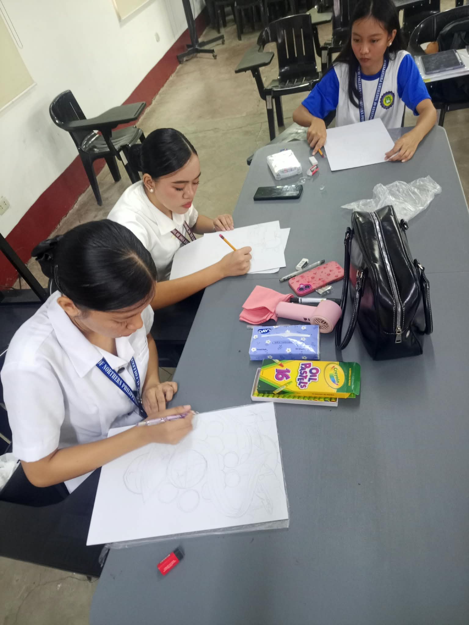 Contestants collaborating and drafting designs on the drawing tables