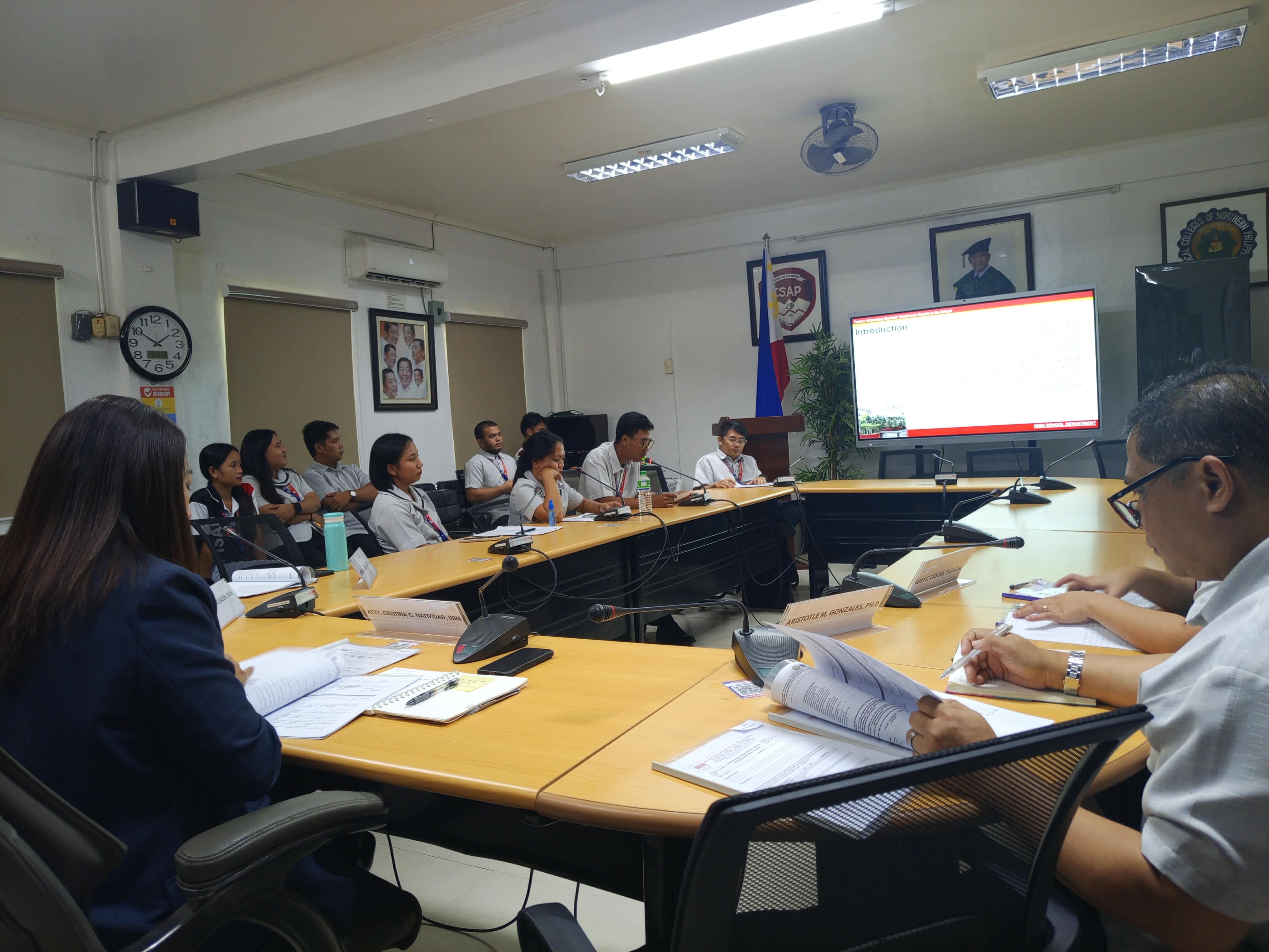 Evaluation panel and academic leaders in conference room discussion