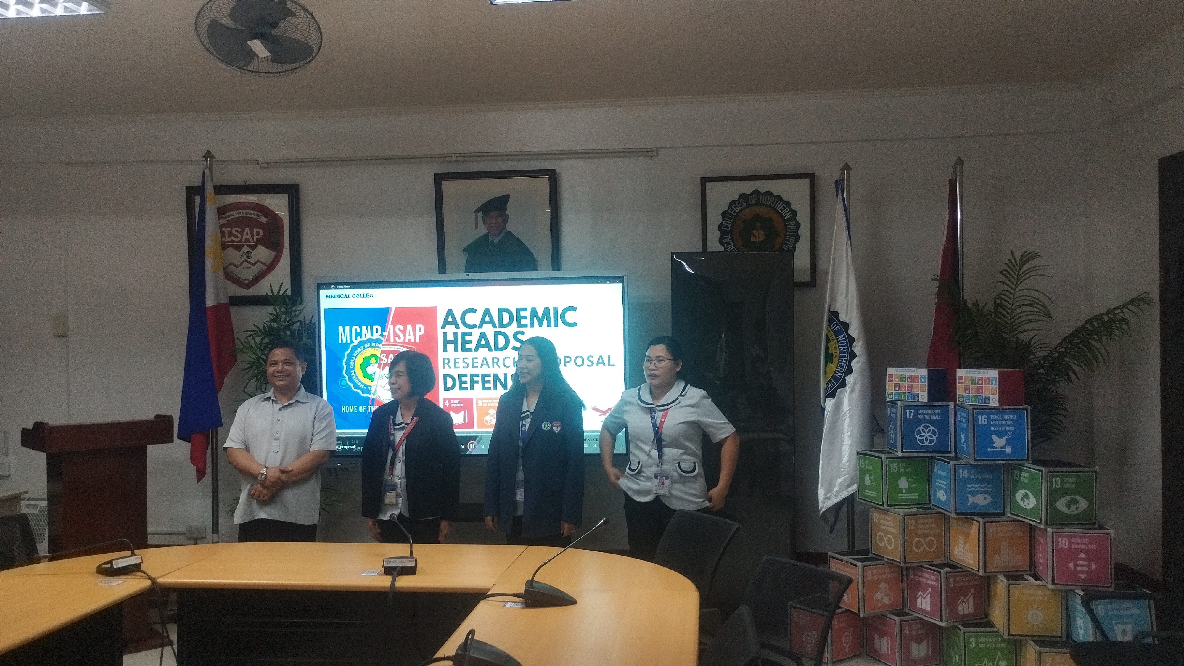 Academic heads and panel engaging in research defense deliberations