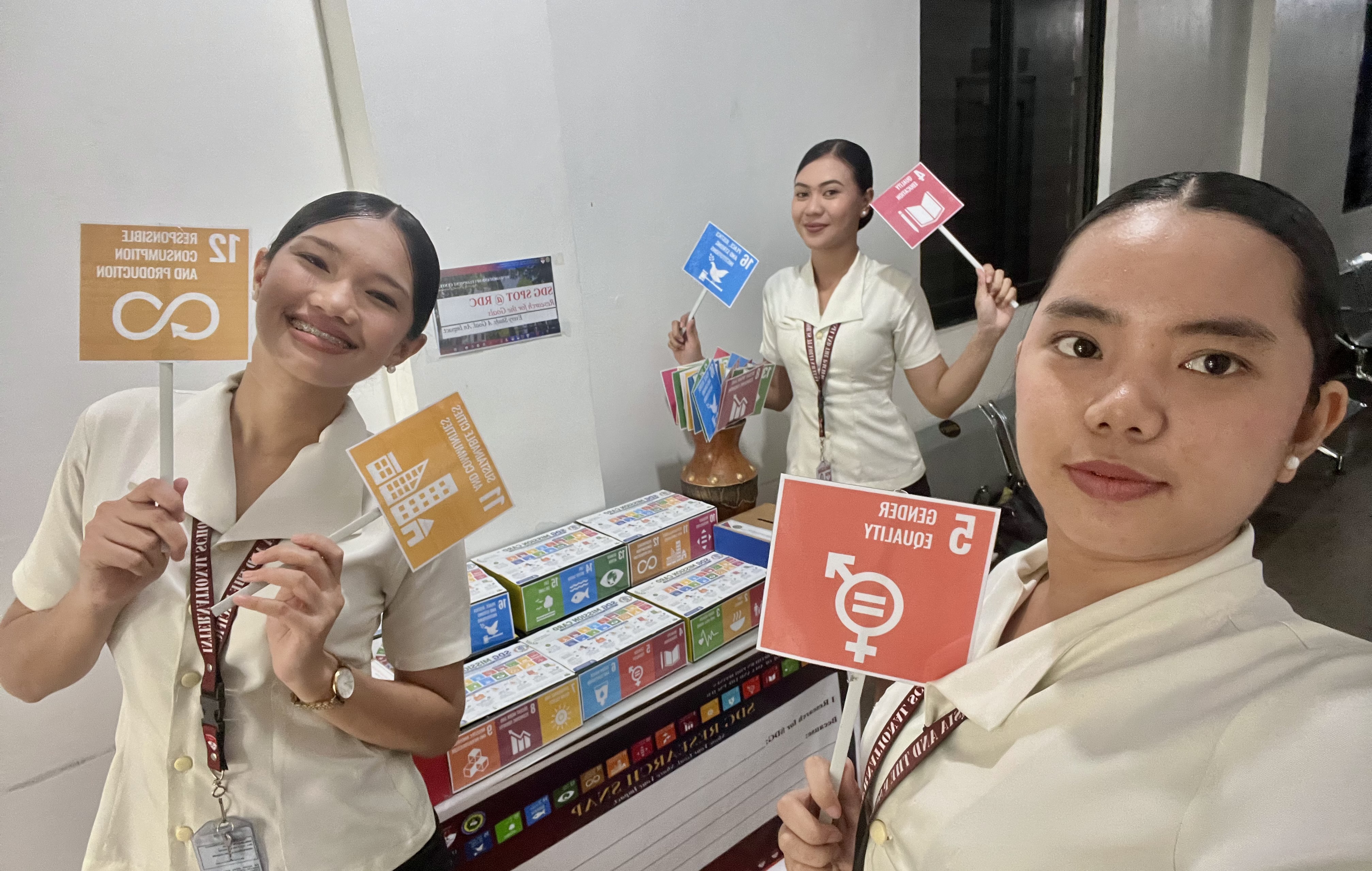 MCNP-ISAP students holding SDG 12, 11, and 5 flags