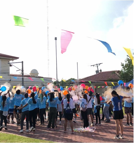 Participants celebrating with colorful balloons and powder burst