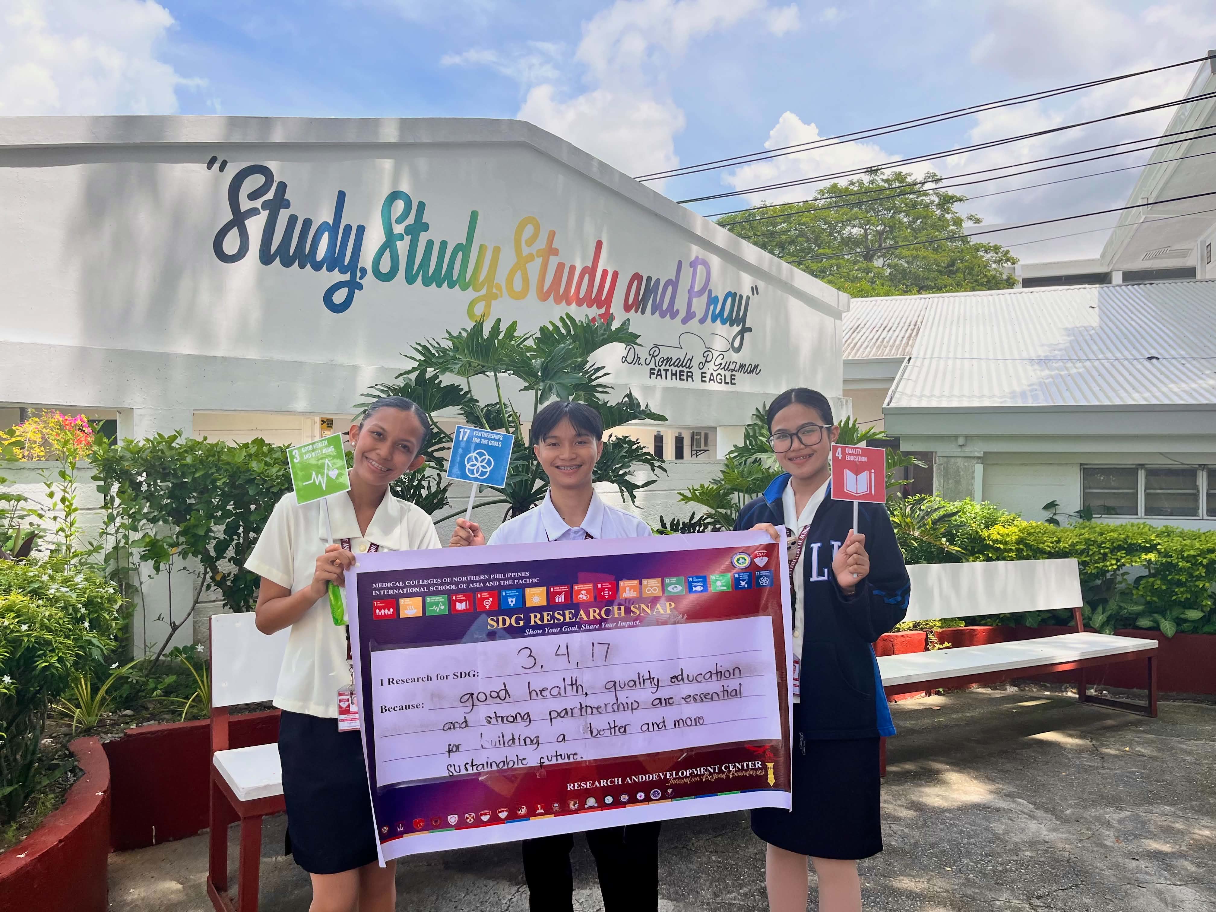 Group of Agcaoili with SDG Research Snap banner and global goal paddles